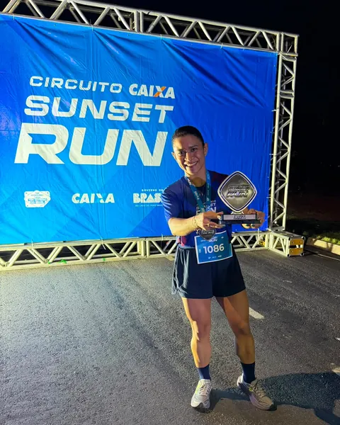 Atleta com troféu na chegada do Circuito Caixa Sunset Run.