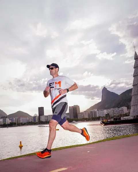 Atleta correndo na Lagoa, com o Cristo Redentor ao fundo.