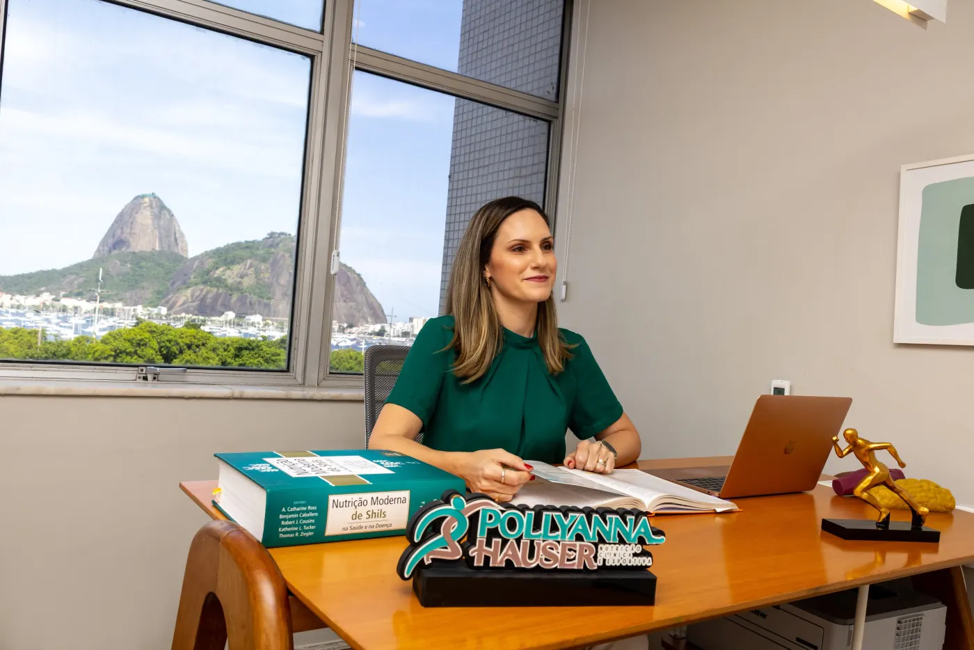Pollyanna Hauser à mesa de atendimento no consultório.